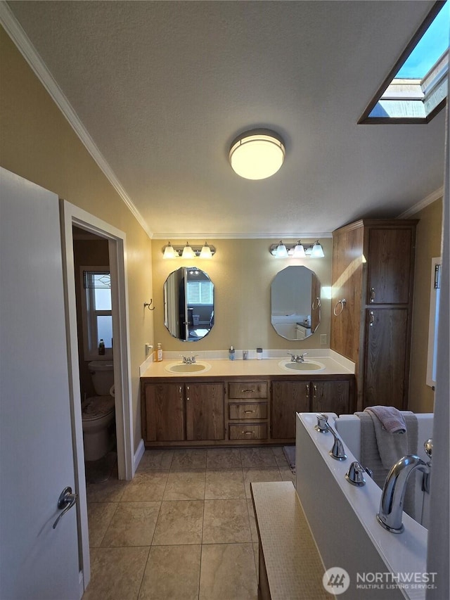 836 E Harman Way E Unit 62, Orting, WA 98360 - bathroom featuring ornamental molding, double vanity, tile patterned floors, and a skylight