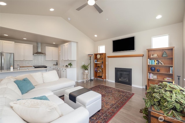 707 Northview St, Bellingham, WA 98226 - living area with vaulted ceiling, ceiling fan, light wood finished floors, a glass covered fireplace, and recessed lighting