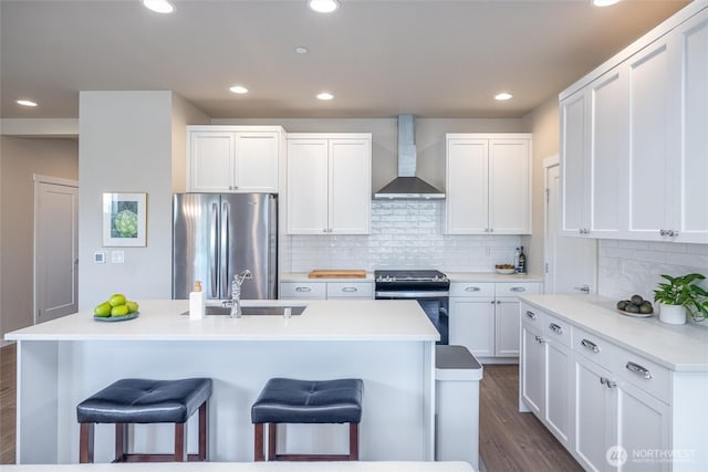 707 Northview St, Bellingham, WA 98226 - kitchen featuring stainless steel appliances, wall chimney range hood, a kitchen breakfast bar, white cabinetry, and dark wood-style flooring