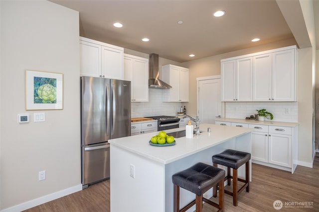 707 Northview St, Bellingham, WA 98226 - kitchen featuring freestanding refrigerator, wall chimney exhaust hood, wood finished floors, a kitchen breakfast bar, and tasteful backsplash