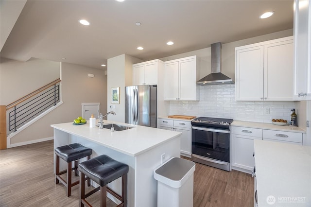 707 Northview St, Bellingham, WA 98226 - kitchen featuring appliances with stainless steel finishes, wall chimney exhaust hood, light wood finished floors, a breakfast bar area, and recessed lighting