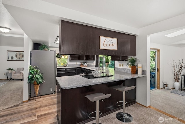 2735 Fordham Ct SE, Lacey, WA 98503 - kitchen with freestanding refrigerator, black electric cooktop, dark brown cabinetry, and a peninsula