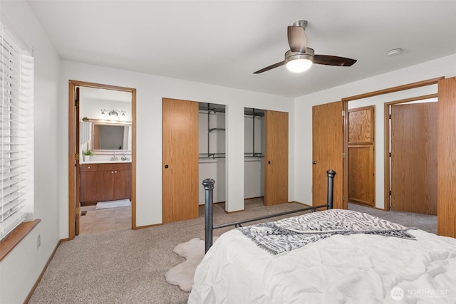 2735 Fordham Ct SE, Lacey, WA 98503 - bedroom with multiple closets, light colored carpet, connected bathroom, and ceiling fan