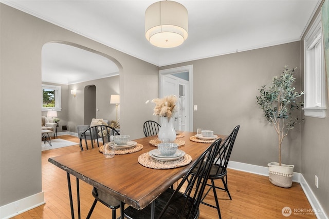 1230 NE 100th St, Seattle, WA 98125 - dining area with arched walkways, light wood finished floors, and crown molding