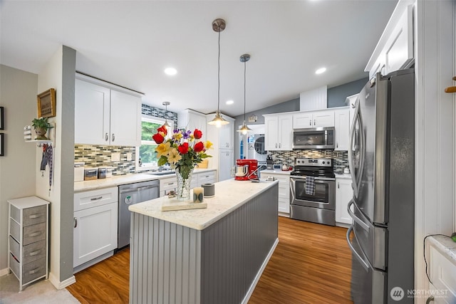 121 E Willapa Rd, Shelton, WA 98584 - kitchen with stainless steel appliances, backsplash, white cabinetry, a kitchen island, and lofted ceiling