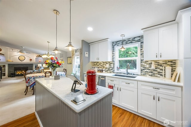 121 E Willapa Rd, Shelton, WA 98584 - kitchen with stainless steel dishwasher, decorative backsplash, a lit fireplace, pendant lighting, and a kitchen island
