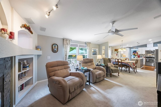 121 E Willapa Rd, Shelton, WA 98584 - living room with a ceiling fan, light colored carpet, a fireplace, and vaulted ceiling