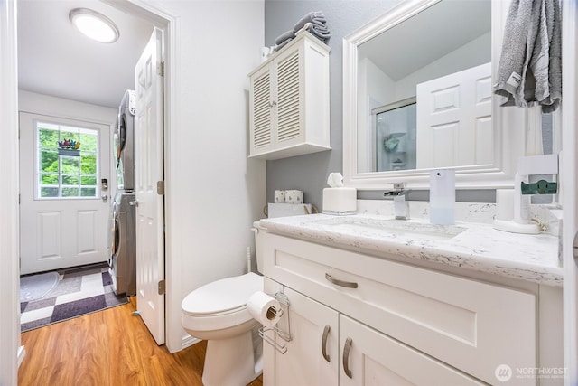 121 E Willapa Rd, Shelton, WA 98584 - full bath with stacked washing machine and dryer, wood finished floors, vanity, and a shower with door