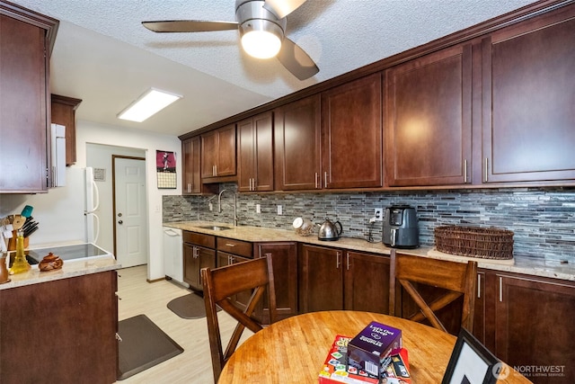 3400 Narrows View Ln NE Unit 204, Bremerton, WA 98310 - kitchen with white appliances, backsplash, light wood-style flooring, ceiling fan, and light stone counters