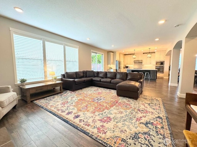 885 N Squire Dr, Ridgefield, WA 98642 - living room featuring arched walkways, dark wood-type flooring, recessed lighting, and a textured ceiling