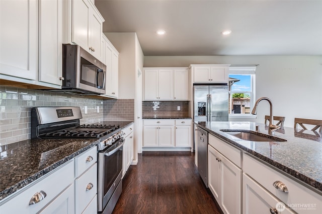 7336 Ashdown Ln SE, Olympia, WA 98513 - kitchen with appliances with stainless steel finishes, dark wood finished floors, dark stone countertops, white cabinets, and recessed lighting