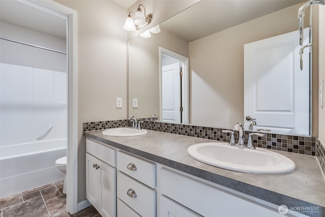 7336 Ashdown Ln SE, Olympia, WA 98513 - full bathroom with double vanity, shower / bathtub combination, tasteful backsplash, and stone finish flooring