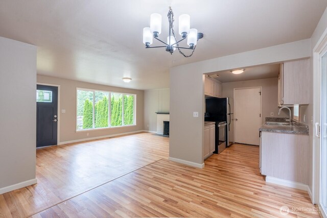 4638 148th Ave SE, Bellevue, WA 98006 - kitchen with stainless steel range with electric stovetop, a chandelier, open floor plan, a fireplace, and light wood-style flooring