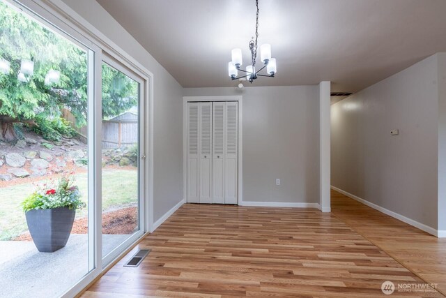4638 148th Ave SE, Bellevue, WA 98006 - unfurnished dining area with a chandelier, light wood finished floors, and healthy amount of natural light