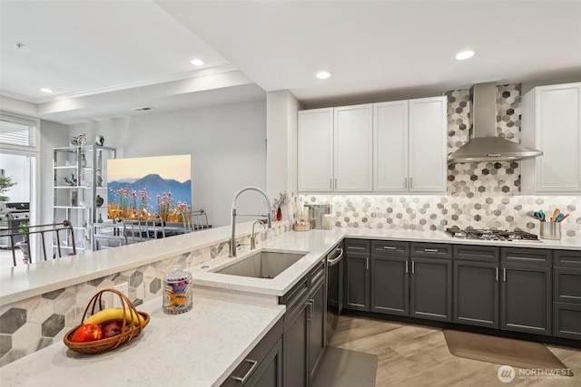 520 6th Ave Unit 2001, Kirkland, WA 98033 - kitchen featuring wall chimney range hood, stainless steel appliances, light wood finished floors, tasteful backsplash, and white cabinets