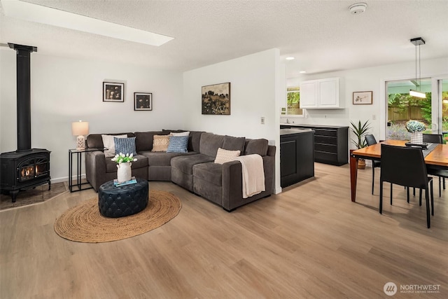 18304 Mclean Rd SW, Vashon, WA 98070 - living room with a wood stove, light wood finished floors, and a textured ceiling