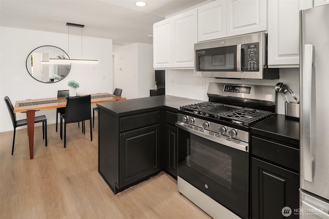 18304 Mclean Rd SW, Vashon, WA 98070 - kitchen with stainless steel appliances, dark countertops, white cabinetry, and recessed lighting