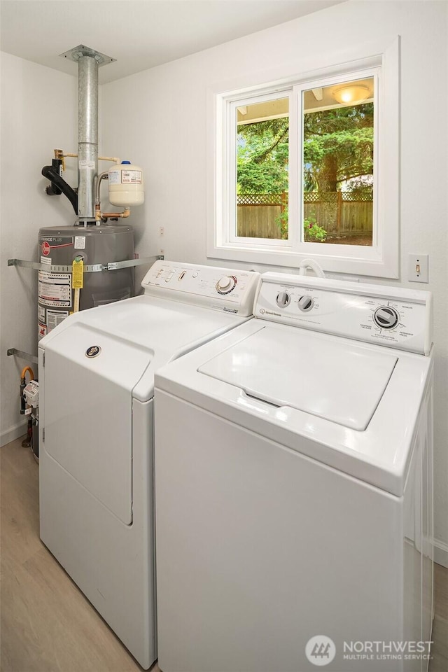 18304 Mclean Rd SW, Vashon, WA 98070 - laundry area with washing machine and dryer, light wood-style floors, and secured water heater
