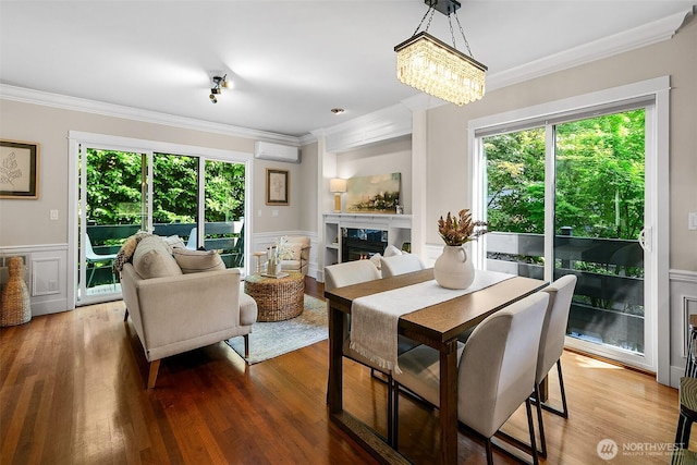 4314 Linden Ave N, Seattle, WA 98103 - dining room featuring crown molding, an AC wall unit, healthy amount of natural light, wainscoting, and a high end fireplace