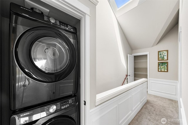 4314 Linden Ave N, Seattle, WA 98103 - washroom featuring stacked washer / drying machine, light colored carpet, wainscoting, a decorative wall, and a skylight
