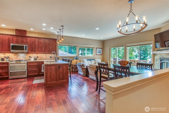 211 Geer Ln, Orcas Island, WA 98245 - kitchen with appliances with stainless steel finishes, open floor plan, a chandelier, dark wood-style flooring, and tasteful backsplash