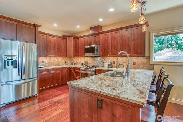 211 Geer Ln, Orcas Island, WA 98245 - kitchen with appliances with stainless steel finishes, a peninsula, wood finished floors, light stone countertops, and recessed lighting