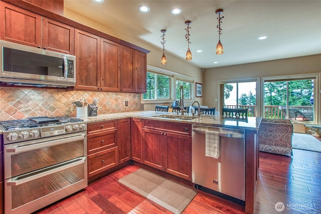 211 Geer Ln, Orcas Island, WA 98245 - kitchen with stainless steel appliances, a peninsula, recessed lighting, dark wood-style flooring, and decorative backsplash