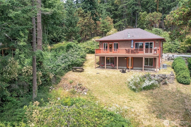 211 Geer Ln, Orcas Island, WA 98245 - back of property with a view of trees, a deck, a yard, and a shingled roof