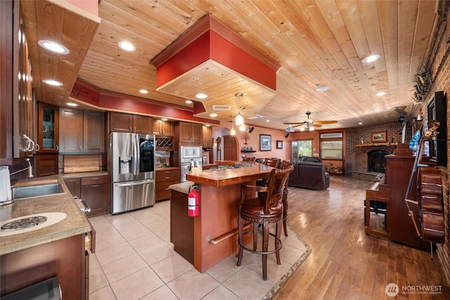 3151 Velvet Ln, Custer, WA 98240 - kitchen with stainless steel appliances, wooden ceiling, wood counters, a brick fireplace, and open floor plan