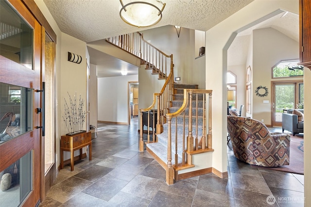 78718 Echols Rd, Hermiston, OR 97838 - foyer with plenty of natural light, stairway, a textured ceiling, stone tile floors, and high vaulted ceiling