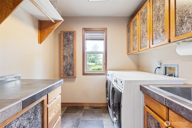 78718 Echols Rd, Hermiston, OR 97838 - washroom with washer and clothes dryer, cabinet space, and dark stone finish floors