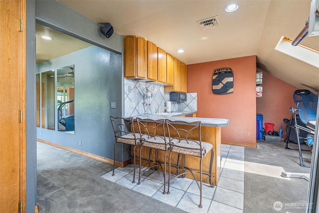 78718 Echols Rd, Hermiston, OR 97838 - kitchen featuring light carpet, lofted ceiling, brown cabinets, decorative backsplash, and recessed lighting
