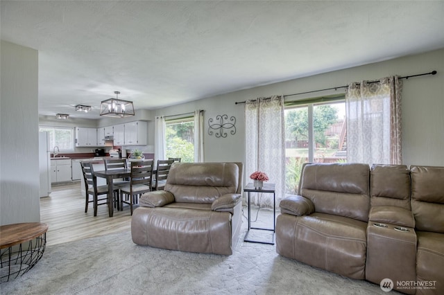 218 Holly Ln, Cosmopolis, WA 98537 - living room featuring plenty of natural light, a chandelier, and light wood finished floors
