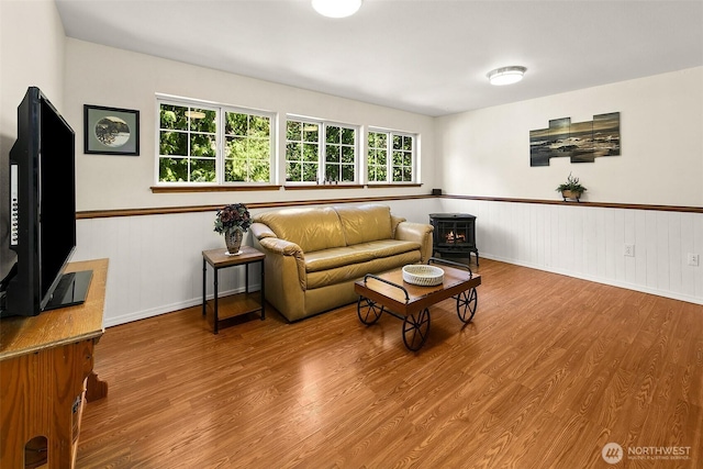 19322 Old Burn Rd, Arlington, WA 98223 - living area featuring wood finished floors, a wood stove, and wainscoting