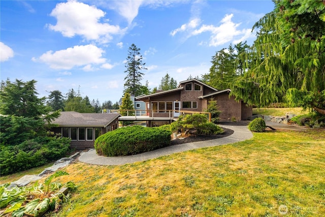 705 Shelter Bay Dr, La Conner, WA 98257 - back of house featuring a sunroom, a lawn, and asphalt driveway