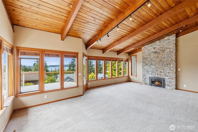 705 Shelter Bay Dr, La Conner, WA 98257 - unfurnished living room with rail lighting, a wooden ceiling with exposed beams, carpet, a stone fireplace, and high vaulted ceiling