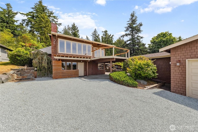 705 Shelter Bay Dr, La Conner, WA 98257 - view of front of property with a chimney, a wooden deck, and a patio area