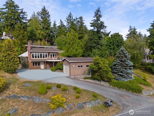 705 Shelter Bay Dr, La Conner, WA 98257 - view of front facade with an outdoor structure, a garage, a chimney, and a wooden deck