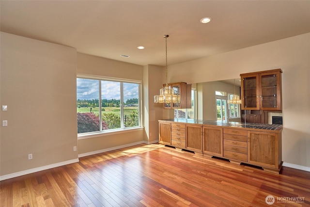 8025 Columbia Way NE, Lacey, WA 98516 - kitchen with a chandelier, light wood-style floors, glass insert cabinets, brown cabinetry, and recessed lighting