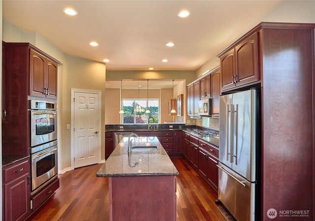 8025 Columbia Way NE, Lacey, WA 98516 - kitchen featuring stainless steel appliances, dark wood-style flooring, recessed lighting, dark stone countertops, and an island with sink