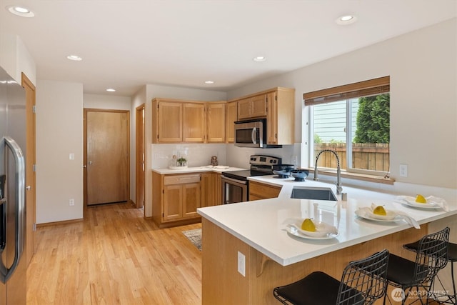 817 Darwins Way, Granite Falls, WA 98252 - kitchen with stainless steel appliances, a peninsula, light countertops, light wood-type flooring, and recessed lighting