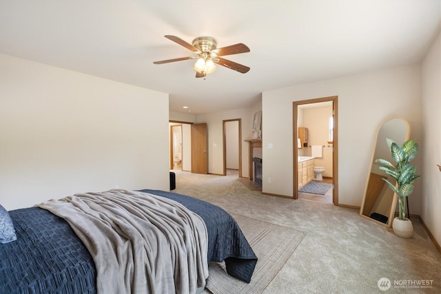 817 Darwins Way, Granite Falls, WA 98252 - bedroom with light colored carpet, connected bathroom, a glass covered fireplace, and a ceiling fan
