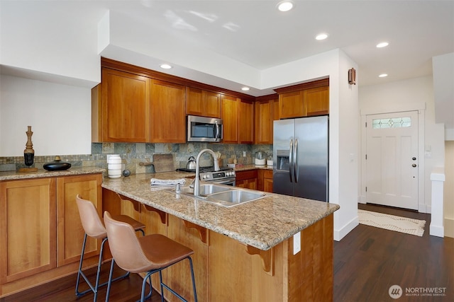 2063 13th Ave W, Seattle, WA 98119 - kitchen featuring stainless steel appliances, brown cabinetry, backsplash, recessed lighting, and a peninsula