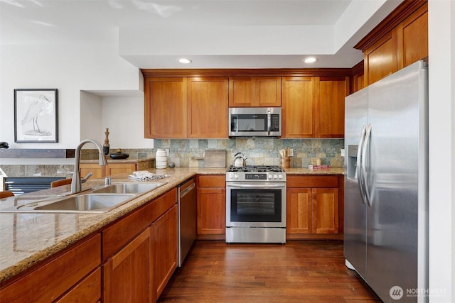 2063 13th Ave W, Seattle, WA 98119 - kitchen with stainless steel appliances, brown cabinets, light stone counters, decorative backsplash, and recessed lighting