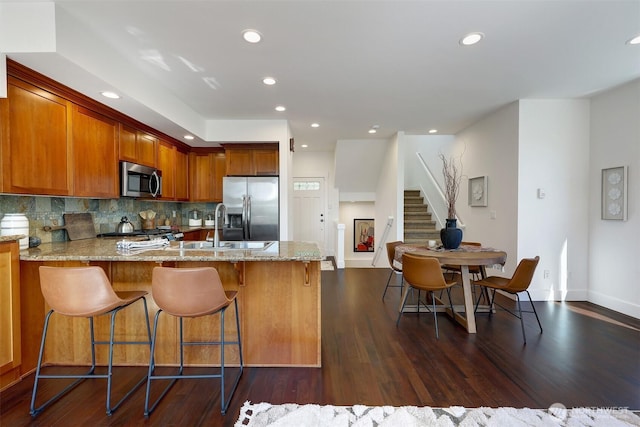 2063 13th Ave W, Seattle, WA 98119 - kitchen with stainless steel appliances, a peninsula, light stone counters, recessed lighting, and tasteful backsplash