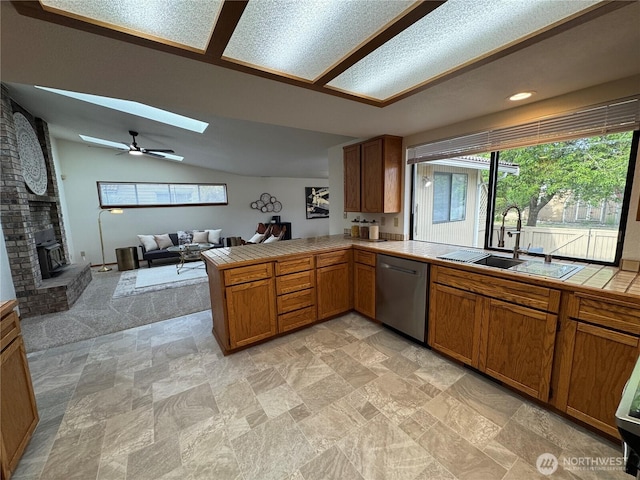18509 22nd Ave E, Tacoma, WA 98445 - kitchen with dishwasher, tile countertops, a brick fireplace, a skylight, and a peninsula