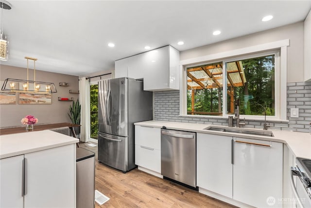 22625 1st Dr SE, Bothell, WA 98021 - kitchen with stainless steel appliances, light countertops, white cabinets, decorative backsplash, and healthy amount of natural light