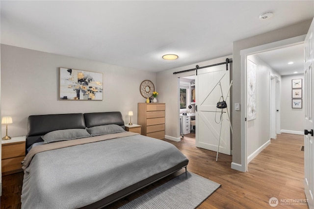 22625 1st Dr SE, Bothell, WA 98021 - bedroom with a barn door, light wood-type flooring, and recessed lighting