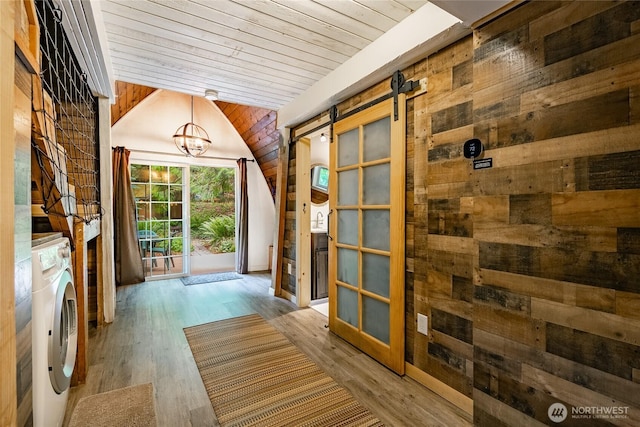 14001 Welcome Rd, Glacier, WA 98244 - doorway to outside featuring lofted ceiling, a barn door, wooden walls, independent washer and dryer, and a chandelier