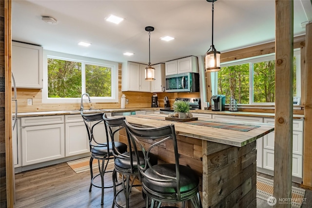 14001 Welcome Rd, Glacier, WA 98244 - kitchen with butcher block countertops, appliances with stainless steel finishes, plenty of natural light, and white cabinetry